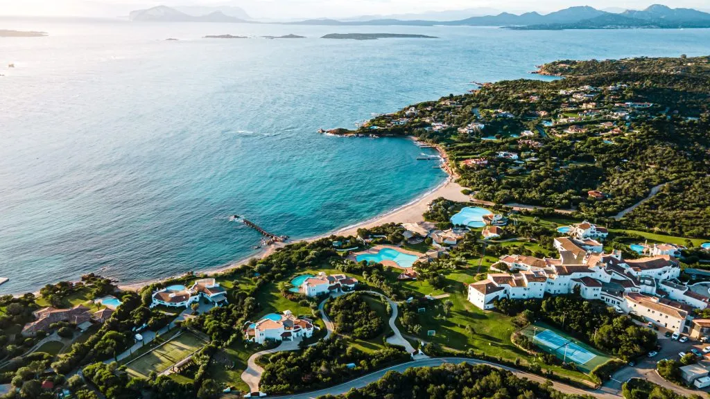 villen und hotels im paradies auf der insel sardinien italien. direkt an der bucht und mit einem bezaubernden weißen strand. perfekt zum schwimmen, tauchen. warmes licht scheint, klares wasser. drohnenaufnahme aus der luft.