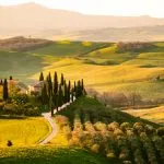 San Quirico d'Orcia, Siena province, Tuscany, Italy. Farmhouse among tuscan hills during harvest period.